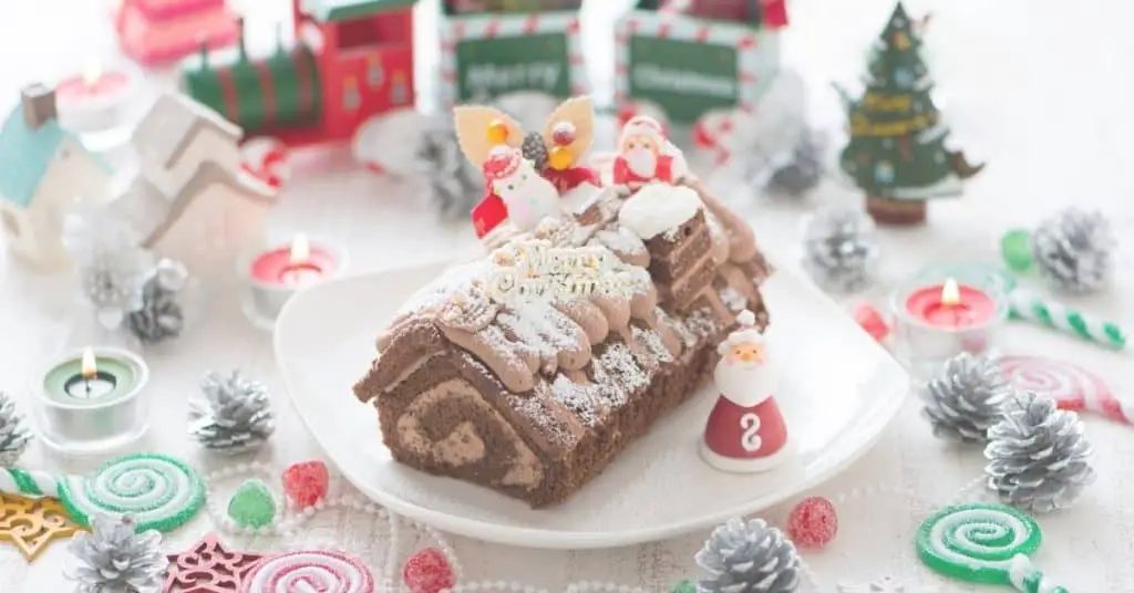 Yule Log Cake Decorated with Santa, snowman and other festive decorations - Open for Christmas