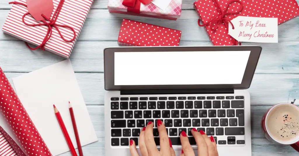 Laptop with lots Christmas gifts around - What To Buy Your Boss for Christmas - Open for Christmas