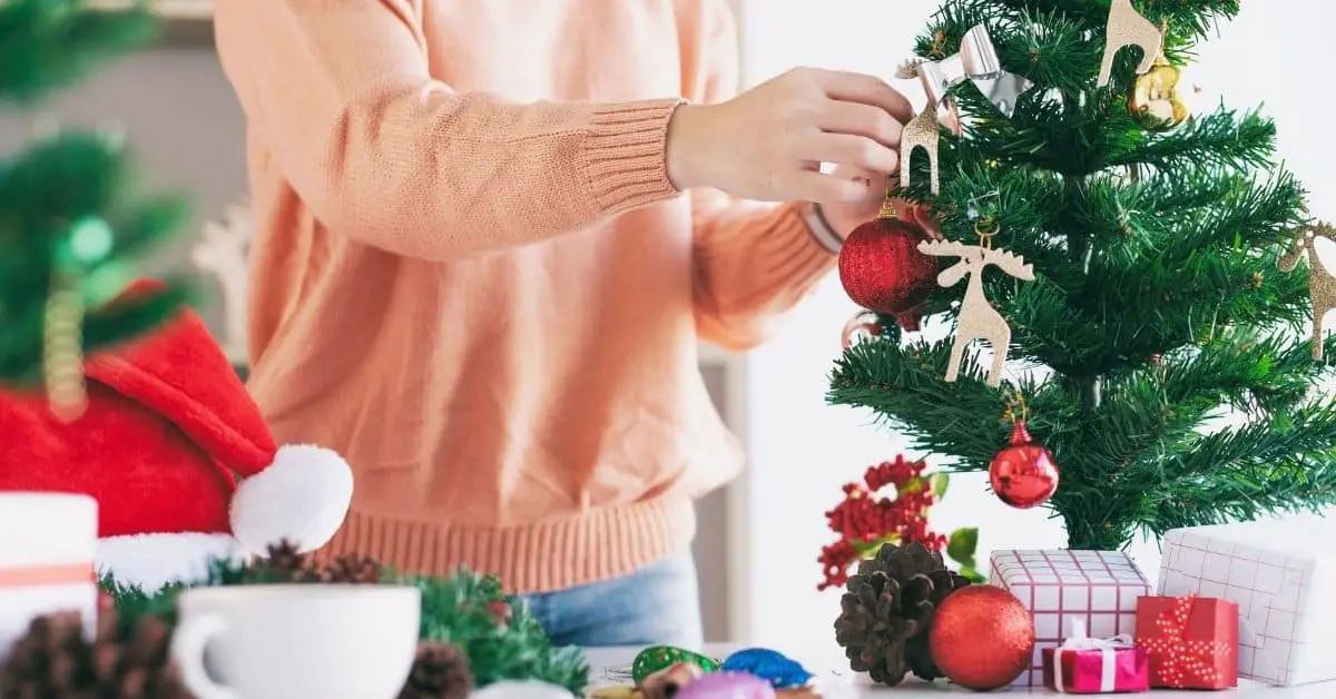 Woman Decorating the Best Small Mini Christmas Tree With Lights and Decorations - Open for Christmas